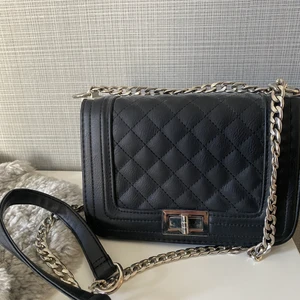 Svart väska  - Svart väska, fint skick använd fåtal gången, bandet går att ha både långt och kort, ett öppet fack med två små fickor på båda sidorna på insidan💓 166kr (fri frakt)