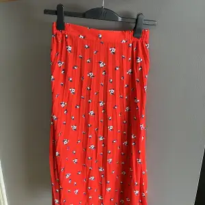 Fin plisserad kjol! Röda färgen med små blommor. Elastiskt midjeband, längd - 75-85cm (längre på sidorna). knappt använd, perfekt skick!