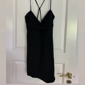 Svart klänning  - Snygg svart klänning från Zara. Modellen är kort med korsade band i ryggen. Aldrig använd och prislappen kvar. Köpare står för frakt💕