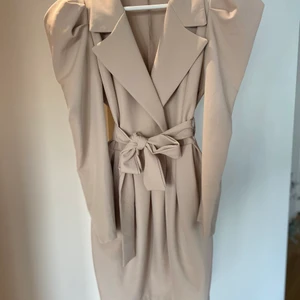 Beige klänning  - En beige klänning med puffärmar och band till markera midjan.  Använd en gång.  Storlek S  Från Nelly.com