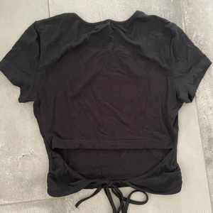 Svart topp med öppen rygg - En svart topp med öppen rygg samt knytning. Superfin och säljs för endast 50kr! Hör av dig vid intresse!💗 frakten är ungefärlig!💗
