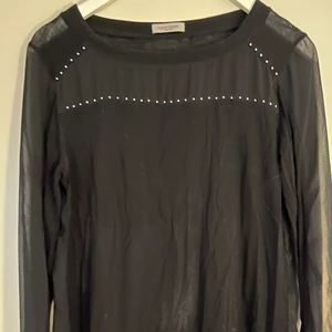 Hunkydory topp - Långärmad topp i skirt material med nitar som dekoration. Sprund i ärmsluten. 