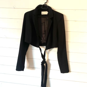 Kavaj topp - Sååå snygg kavaj topp i kortare modell, storlek 36, från Nelly! Banden knyter man runt midjan något varv