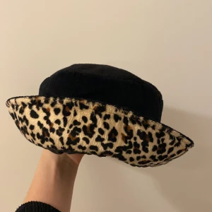 Hatt  - Svart och leopard mjuk och skön hatt. Inte direkt värmande men fin!  Hämtas hos mig Göteborg eller skickas mot att köparen betalar frakt.