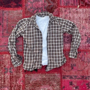 Skjorta från dressman - Vintage style skjorta med ett ballt mönster och hostiga färger, kan va svin snyggt över en hoodie elr t shirt som man ser i bilden. Säljer den pågrund av den är för liten för mig men den kan va riktigt snygg på någon annan (skriv gärna för mer info!)