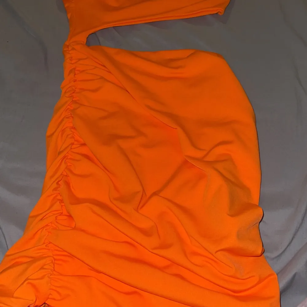 En neon orange klänning väldigt tajt så om du har stora bröst så kommer klänningen inte passa Har imga bilder på klänningen då jag inte kan sätta på mig den  . Klänningar.