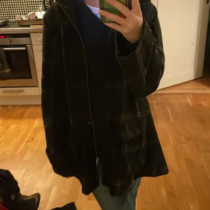 rutig kappa - rutig svart kappa me luva från märket eastwest storlek s