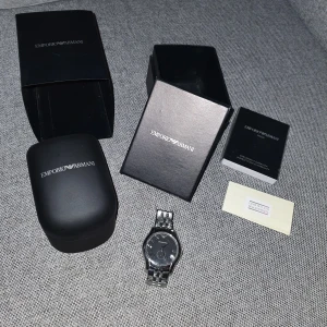 Armani klocka - Super fin Armani klocka i förpackning.  Äkthetsbevis finns, lite repig samt behövs bytas batteri.   Möts upp, eller fraktar mot fraktkostnad!