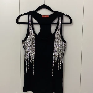 Svart topp med glitter  - Svart topp med glitter storlek M-L i bra kvalitet. 