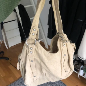 Kappahl Vintage beige linneväska  - Vintage beige linneväska med silver detaljer från Kappahl.  Från 90-talet/ tidigt 20-tal. Väskan är endast använd 3-5 ggr och är i bra kvalite, som ny!☺️