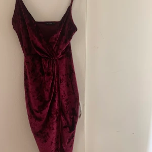 Vinröd sammets klänning  - Så fin vinröd klänning från Nelly! Uringingen är superfin och materialet är så skönt! 