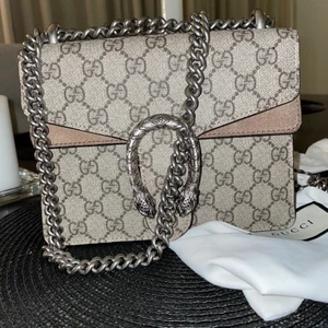 Gucci Dionysus GG Supreme mini bag  - En Gucci Dionysus GG Supreme mini bag i nästan nyskick, skedde en olyckshändelsen vid sidan av väskan av en penna och därför för säljer jag den för de priset men annars så är väskan i topp skick/ nyskick. Har använt den några gånger och tänkte nu ta tag och sälja den. Har dock inget kvitto då jag fick den i presenter. Men i väskan finns ett Qr nr som jag har lagt upp. 