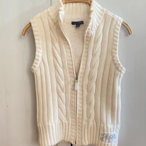 Kabelstickad väst med Teddy insida - Säljer denna vita, kabelstickade väst med superskönt innermaterial (se bild 2), från Tommy Hilfiger. Superfint skick! Storlek 12-14 år, upplevs som en XS.
