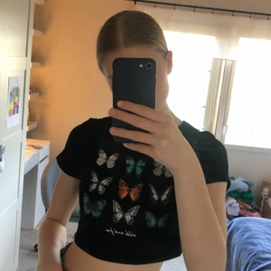 Svart topp med fjärilar - En kroppad svart T-shirt med fjärilar på från shein i strl S, använd typ 1 gång. 40 kr +frakt. Betalning via swish💜💜