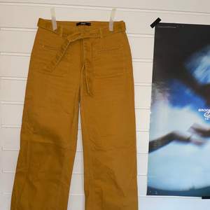 Gula jeans med tillhörande skärp från Bikbok. Superhärlig färg till våren och sommaren! Hög midja och vida ben. Längd: ner till fötterna på mig som är 173 cm lång. 100% bomull 