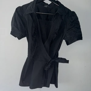 Topp - Jätte fin svart omlottblus från hm💕 har en jätte fin passform och perfekt när man vill vara extra fin! Är i stället 38 och skulle säga att den passar 34-38 då den är sjusterbar💝💝