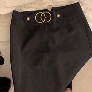 Svart kjol  - Svart tight kjol, med dragkedja bak och gulddetaljer 