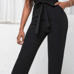 Jumpsuit - Snygg jumpsuit/ hängselbyxor i mjukt kostym material.. Endast testad, nyskick