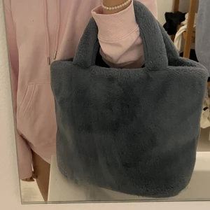 Fluffig väska - Säljer nu min älskade pälsväska från na-kd! Flitigt använd men har trots det inga defekter! En väska som klarar allt i både vått å torrt med andra ord 🥰 RYMLIG ❣️ säljer då jag köpt en ny väska i samma storlek!