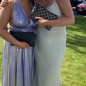 Balklänning - Lila, skimrig balklänning med V-neck!💕Kan knytas som på bilden eller också runt halsen, snurra banden osv😍 Uppsydd för att passa mig som är 157 (har 5 cm klack så längden är ca 162) Hör av dig för fler bilder🥰 OBS väldigt fint skick!!!