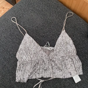 Glittrig topp  - Glittrig festlig topp från PULL&BEAR i storlek M, aldrig använt 