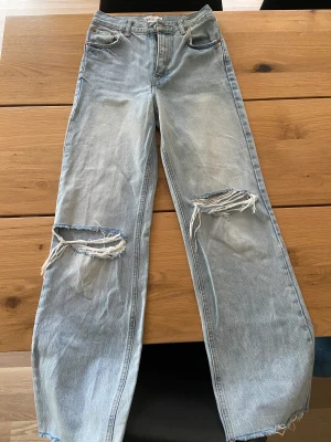 Zara Jeans high waist wide leg - Ett par high waist wide leg jeans från Zara, strl 34 (small-xs) med ripped knän. 72 cm midjemått 78 cm innerbenslängd 107 cm ytterbenslängd