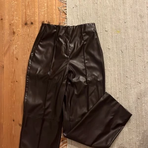 Skinnbyxor - Bruna skinnbyxor ifrån hm i storlek 38. Har ett sytt pressveck fram och fickor på sidorna. Raka i benen och resår i midjan!  Säljer pga använder inte längre!  Köparen står för frakten! 