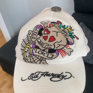 Ed Hardy keps med detaljer - Går att justera passformen för huvudet. Bra skick med liten fläck under kepsen som inte syns. MÅNGA ÄR INTRESSERADE SÅ LÄGG BUD!:)