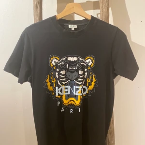 Kenzo T-shirt - Säljer nu min kenzotröja då den inte är min stil längre. Den är använd ett fåtal gånger och sitter mer åt slimfit hållet. Den sitter bra över kroppen och tajtare runt armarna på mig som är en S/M i storleken.