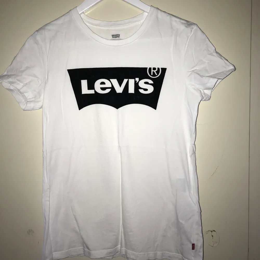 Vit Levis t-shirt med svart tryck. Trycket är i sånt mjukt material (?) Fint skick, i stort sett aldrig använd . T-shirts.
