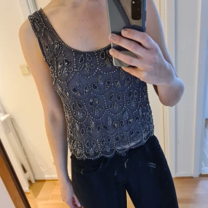 Topshop top - Fin cropped grå tol helt broderad i pärlor. Innerfoder. Använd 3 ggr. Frakt betalas av köparen, kan lämnas i Malmö. 
