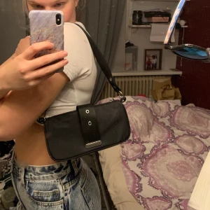 Svart axelväska - Sjukt snygg axelväska från weekday, använd några fåtal gånger så den är i perfekt skick men säljer pga får inte användning av den längre. 