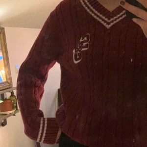 Stickad tröja - Vinröd stickad tröja med vita detaljer. Andvänt men fint skick. Köpare står för frakt