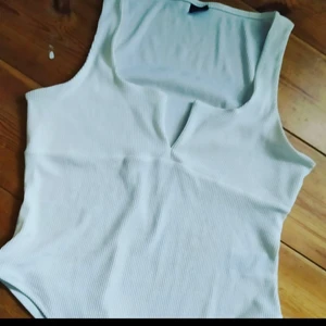 Skitsnygg Body med v-ringning! - Fr Gina Tricot, använd en gång. Den sitter sjukt snyggt på och är bekväm och i V:et är det typ som ståltråd så att inte urringningen "faller" ihop. Djur och rökfritt hem.Frakt tillkommer på 44:- jag samfraktar gärna!