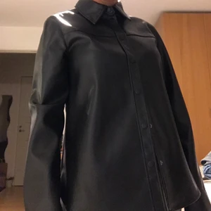 PU skjorta från H&M - En jättefin skjorta i fake läder från H&M! Aldrig använd och i storlek 36. Den är jättefin att ha som OverShirt och vanlig skjorta. 