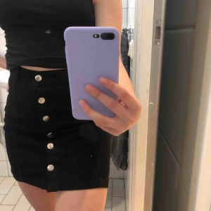  - Svart jeanskjol med knappar hela vägen framtill. Väldigt stretchigt material. 