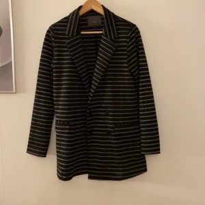 Kavaj strl S - Randigtglittrig kavaj från ICHI i storlek S. Använd fåtal gånger. Kan mötas upp i Halmstad eller frakta (fraktpris tillkommer)