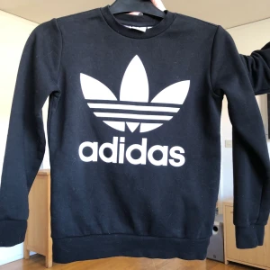 Adidas - Svart tjocktröja från adidas! Bra skick men använd några gånger. Storleken är 146/152 men passar en XS. Originalpris 399kr. Frakt ingår inte i priset utan betalas utav köparen! Hör gärna av dig om du har några funderingar eller frågor!