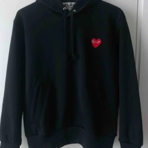 CDG Play Hoodie svart storlek small - Nu säljer jag min cdg hoodie i storlek small.   Kvalitet 9/10 eftersom den är använd några gånger.  Självklart äkta och köpt på Paul & Friends i NK. Kvitto finns!  Fråga gärna om ni undrar något! Nypris:2300kr