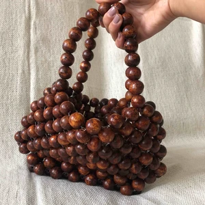  - Liten handväska gjord av bruna träkulor. Nyskick!  Hämtas upp i Stockholm eller köpare står för frakt.