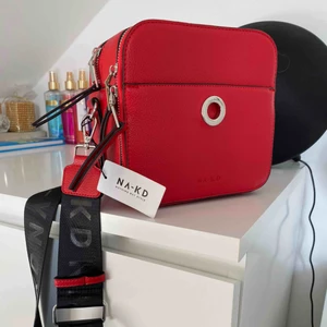  - Röd väska från nakd. Både smalt och tjock band medkommer. Väskan har flera fack och rymmer mycket 