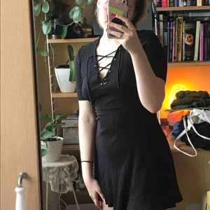  - Svart, kort klänning med snörning från HM. Storlek 34, men passar 34-en liten 38