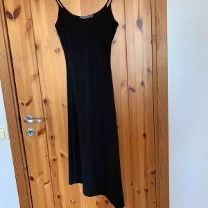  - Svart klänning som är snedskuren ner till, en XS men  passar en S , köparen står för frakten.