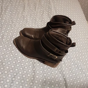 Ett par bots. - Det är er töar mörkbruna bots med en detalj ring som går micke rätt att ta bort.