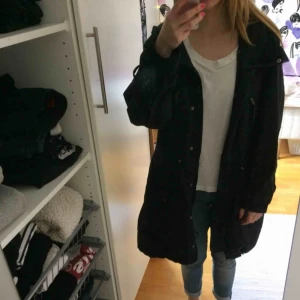  - Svart regnkappa som tyvärr är alldeles för stor för mig