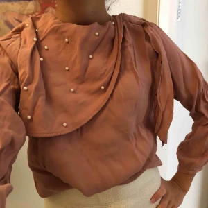  - Blus från ZARA i gammalrosa färg med pärlor framtill och öppning i ryggen. Behöver strykas. Skickas mot frakt annars hämtas i Stockholm. Färgen ges rättvisa i sista bilden. 