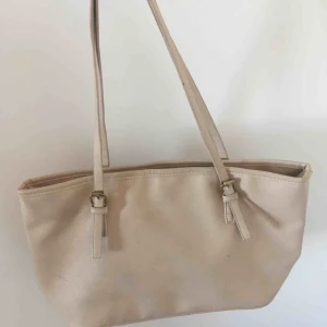  - En snygg beige väska lite trasig på bandet men inget större, använd ganska mycket förra året 😀