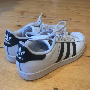 Adidas Superstar storlek 40 2/3 - Adidas Superstar storlek 40 2/3 (US 7 1/2, UK 7). Använda en gång