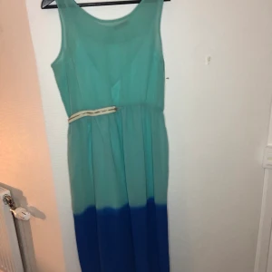 Lång ombre blå klänning från Nelly - Blå ombre klänning från Nelly som kommer med en passande underklänning. Passar jättebra ovanför en bikini. Den har bara använts en gång. Storlek:40 