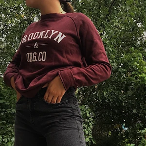  Vin röd sweatshirt  - Säljer en vin röd sweatshirt som har en text på framsidan där de står ”Brooklyn” som aldrig kommit till användning som är i storlek xs